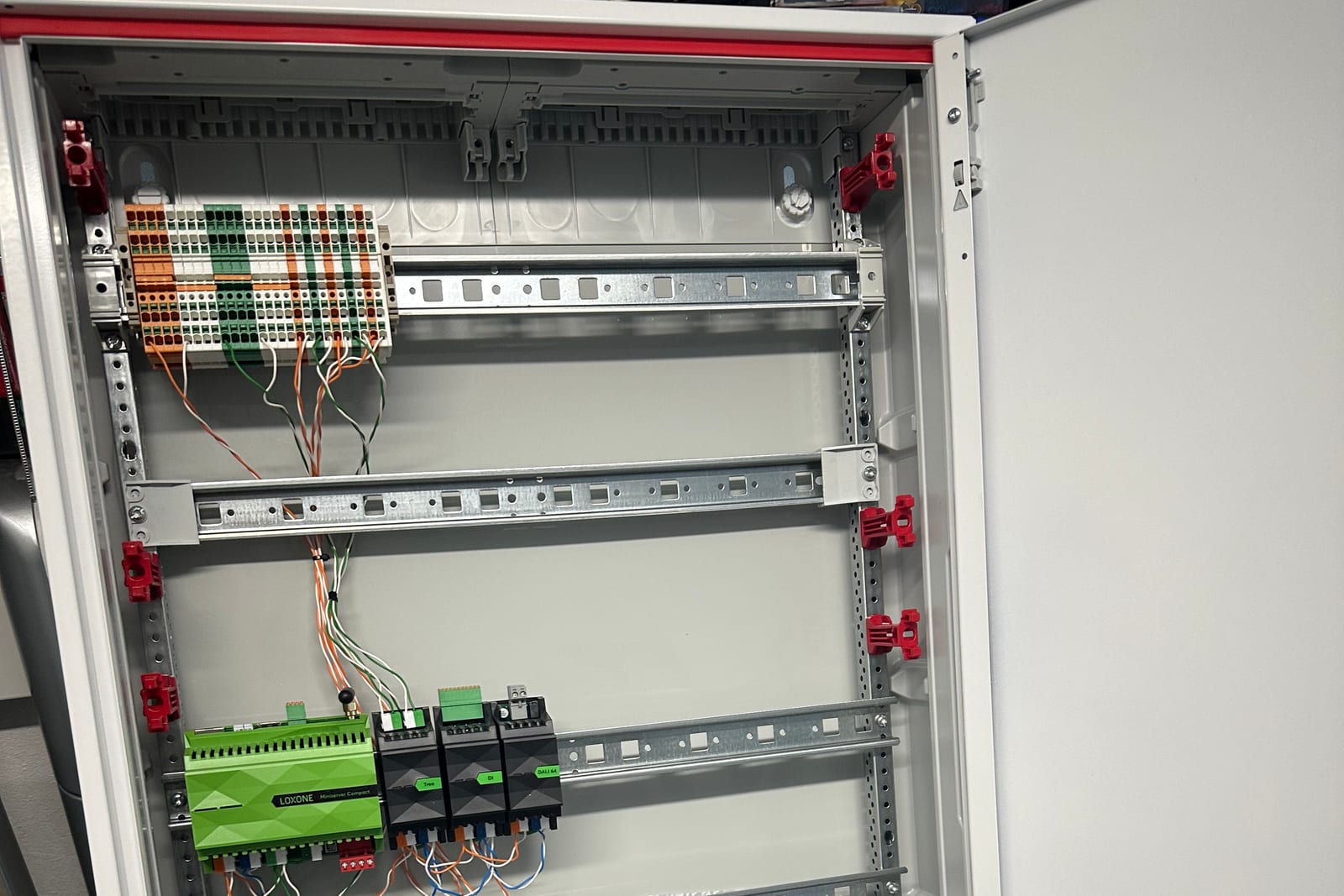 Schaltschrank im Aufbau: DIN-Schienen, Miniserver Compact und verdrahtete Klemmen
