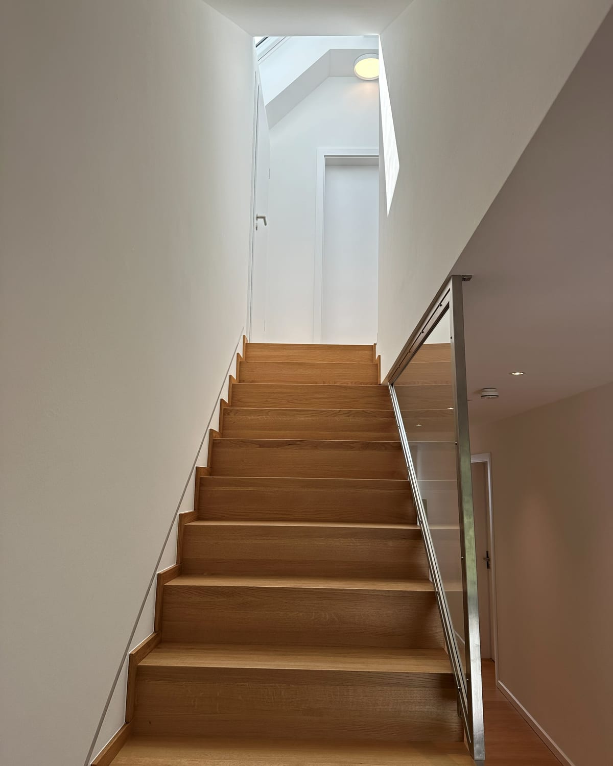 Treppe mit Eichenstufen und Glas-/Stahlgeländer, Oberlicht am oberen Absatz