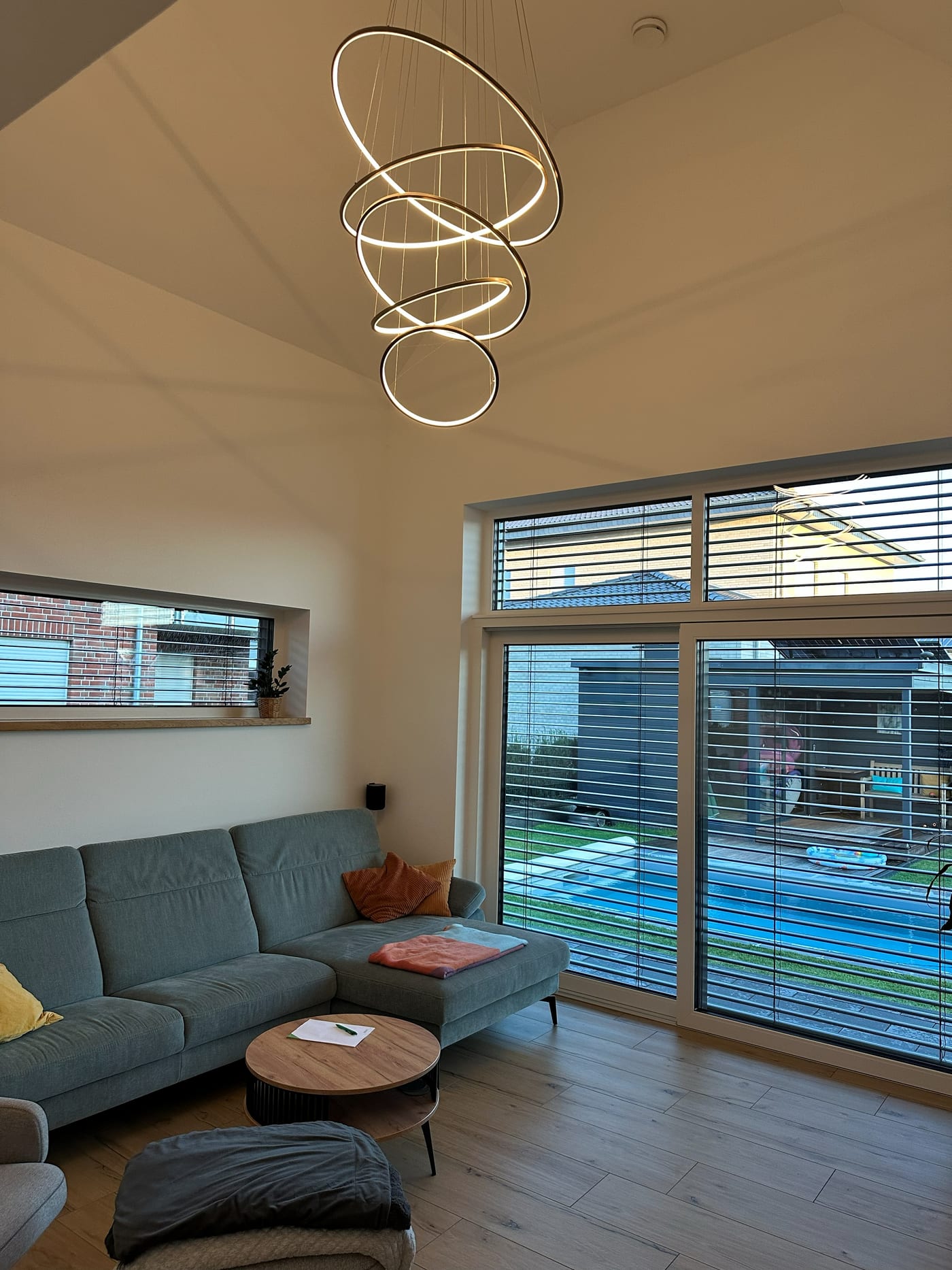Unser Wohnzimmer am Abend, Ringpendelleuchte in Ebenen an, Raffstore vor der Terrassentür bereits heruntergefahren