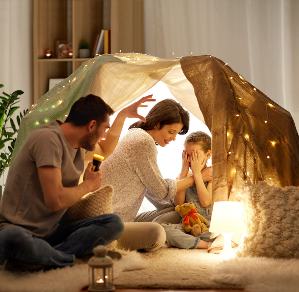 Familie sitzt in einem beleuchteten Zelt